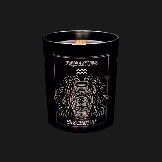 A black candle with the Aquarius zodiac sign design in gold. The candle is labeled 'Aquarius' and has a lit flame at the top.