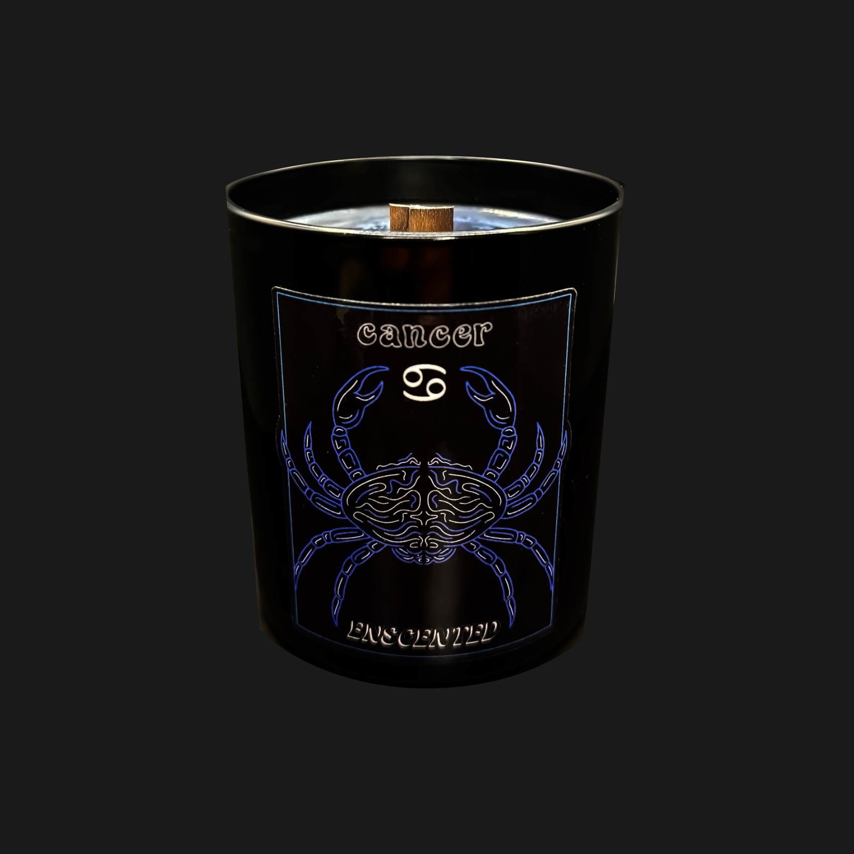A black candle with a blue and white design featuring the Cancer zodiac sign as a crab, along with the name 'Cancer' written on it. The candle has a wooden wick and emits a slight frosted appearance.