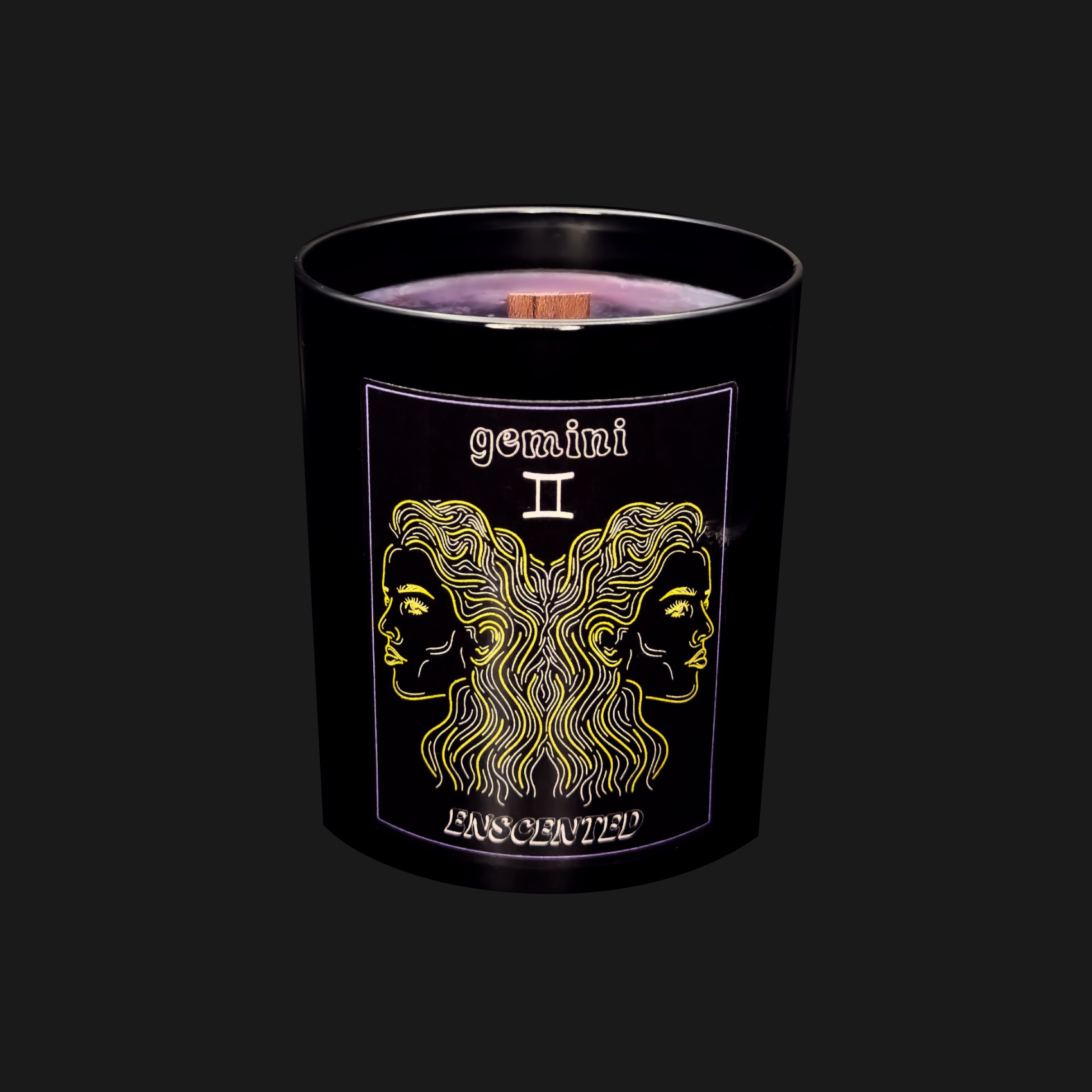 A black candle with a gold and purple label featuring the Gemini zodiac sign.