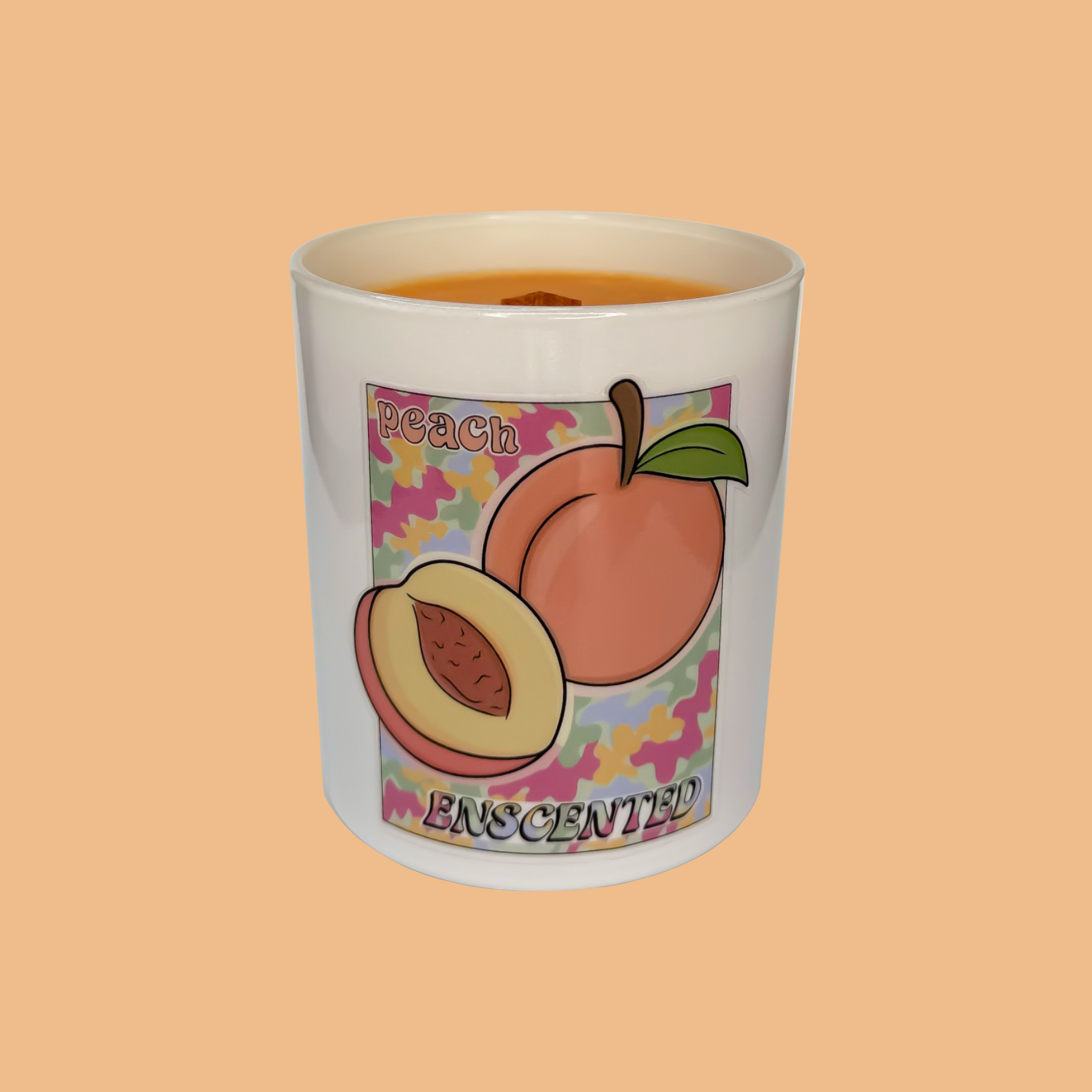 A white candle with a peach illustration and the word 'PEACHESCENTED' written on it, set against an orange background.