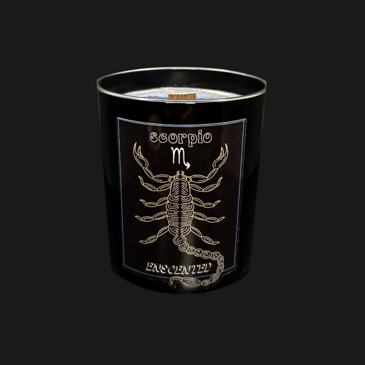 A black candle with a gold label featuring the sign of Scorpio, including an image of a scorpion and celestial symbols.