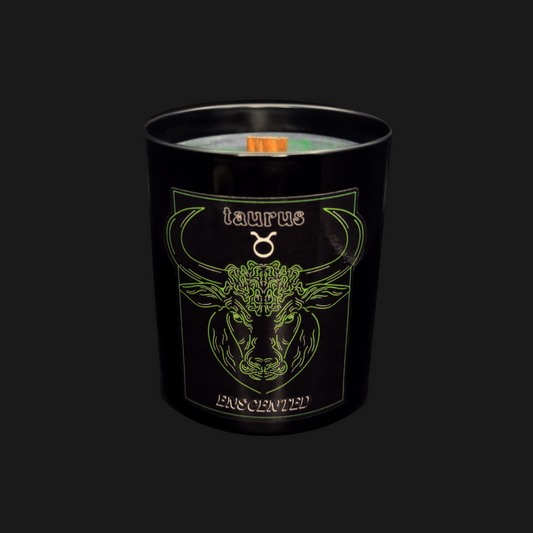 A black candle with a graphic of a bull, representing the Taurus zodiac sign, and a label indicating it is a Taurus scented candle.
